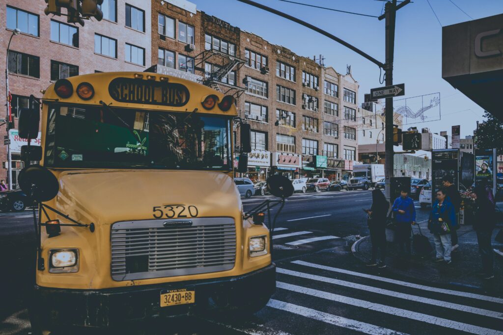 Group of students boarding a safe school trip bus rental in NYC with ZoloBus driver Group of students boarding a safe school trip bus rental in NYC with ZoloBus driver