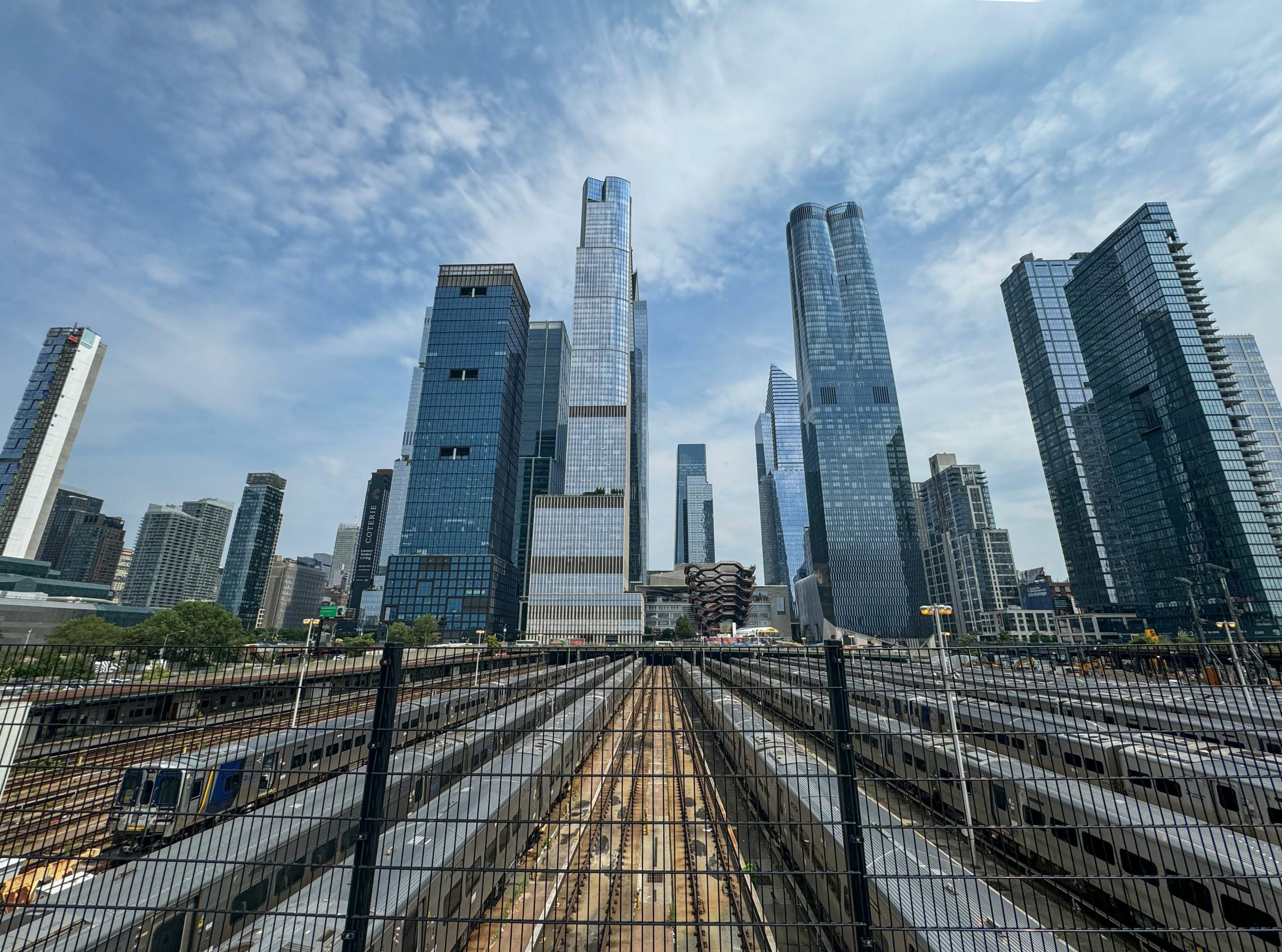 View of modern skyscrapers and train tracks in New York City, a busy urban scene.