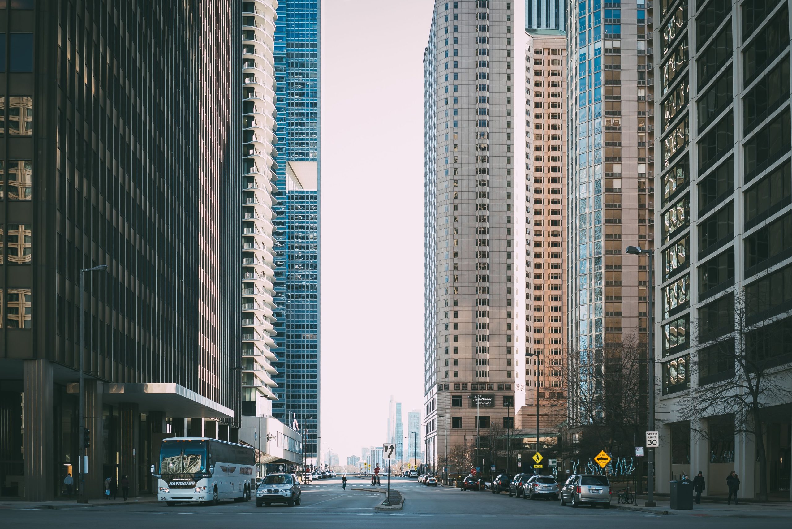 Charter Bus Rental NYC Pricing: 6 Honest Seasonal Cost Truths for 2026 4 Vibrant city street scene with tall skyscrapers and city life full of cars and pedestrians.