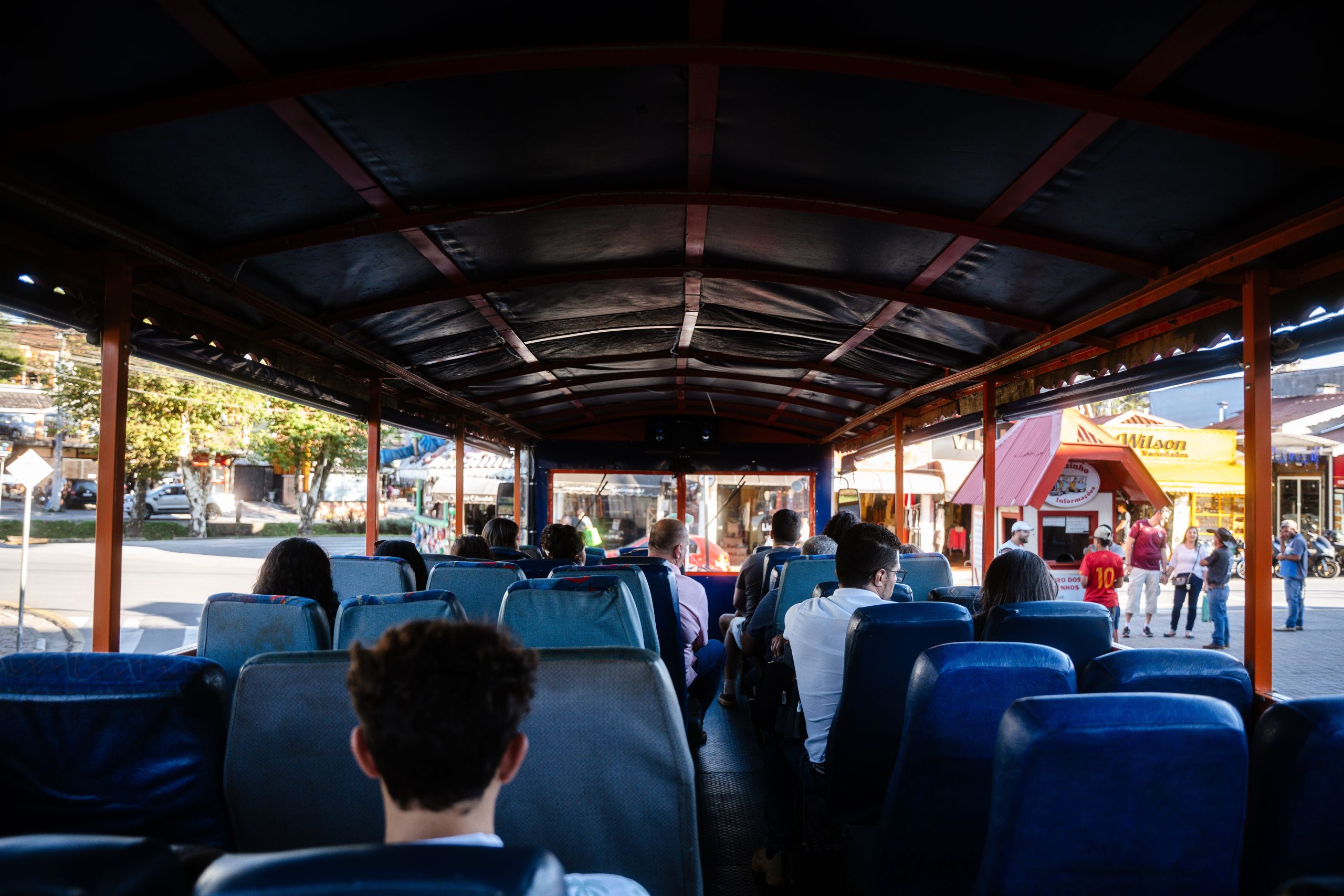 Group Tour Transportation in NYC: A 2026 Survival Guide for Moving Your Crew 1 Passengers on an open-top bus enjoying a city tour in Campos do Jordão, Brazil.