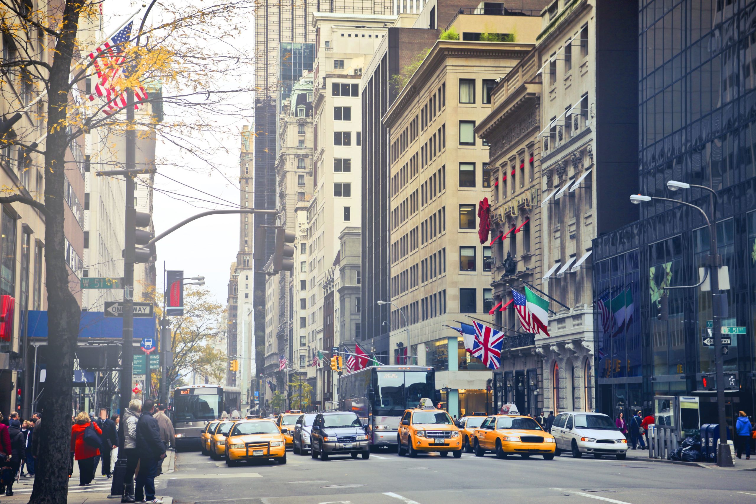 Busy New York City street with iconic taxis, buildings, and international flags