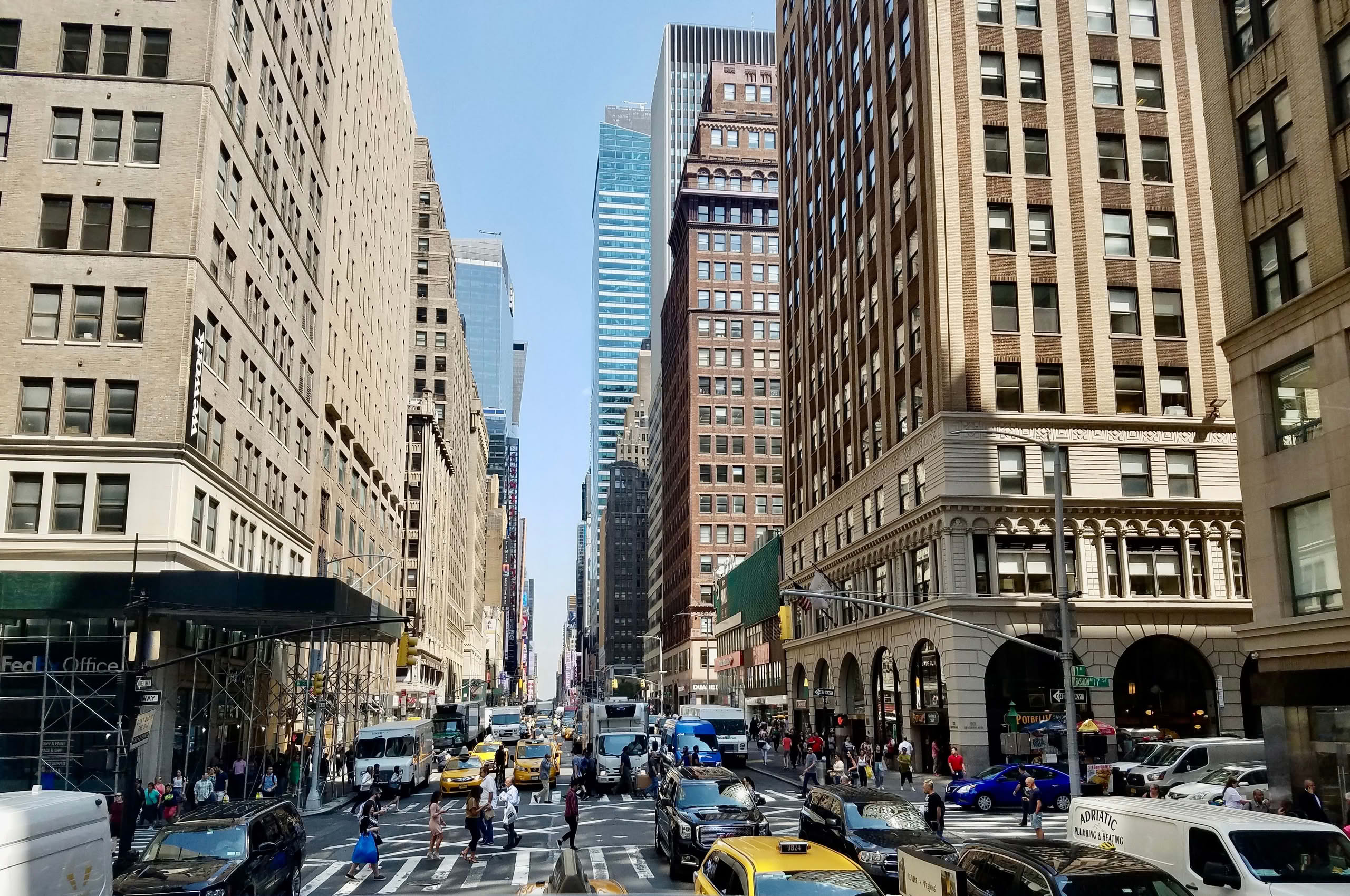 Vibrant New York City street with skyscrapers and traffic in daylight.
