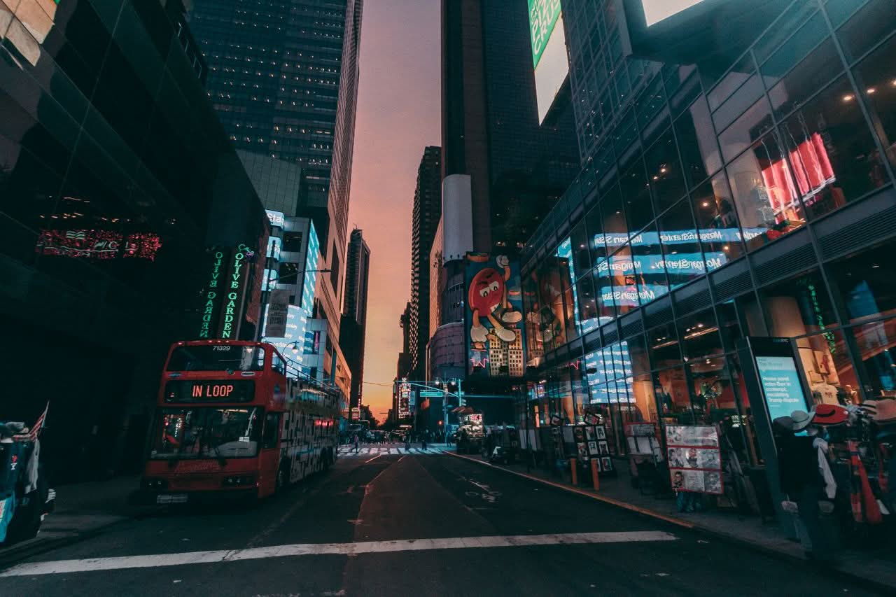 How to Choose Bus Companies in NYC: 7 Honest Checks for 2026 2 Dynamic NYC street scene with skyscrapers and traffic at dusk.