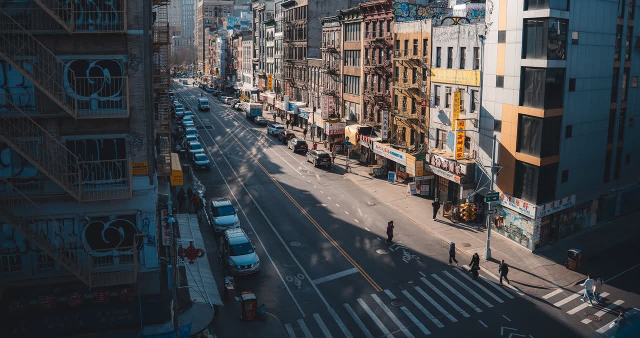 Affordable Minibus NYC: The Honest 2026 Booking Guide 1 Street view of Chinatown in New York City with pedestrians and historic buildings.