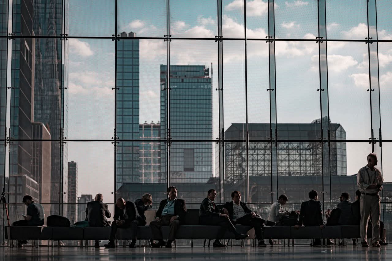Minibus NYC For Groups: 7 Honest First-Timer Tips (2026) 9 Business professionals at the Javits Center, New York City featuring urban skyline through glass facade.