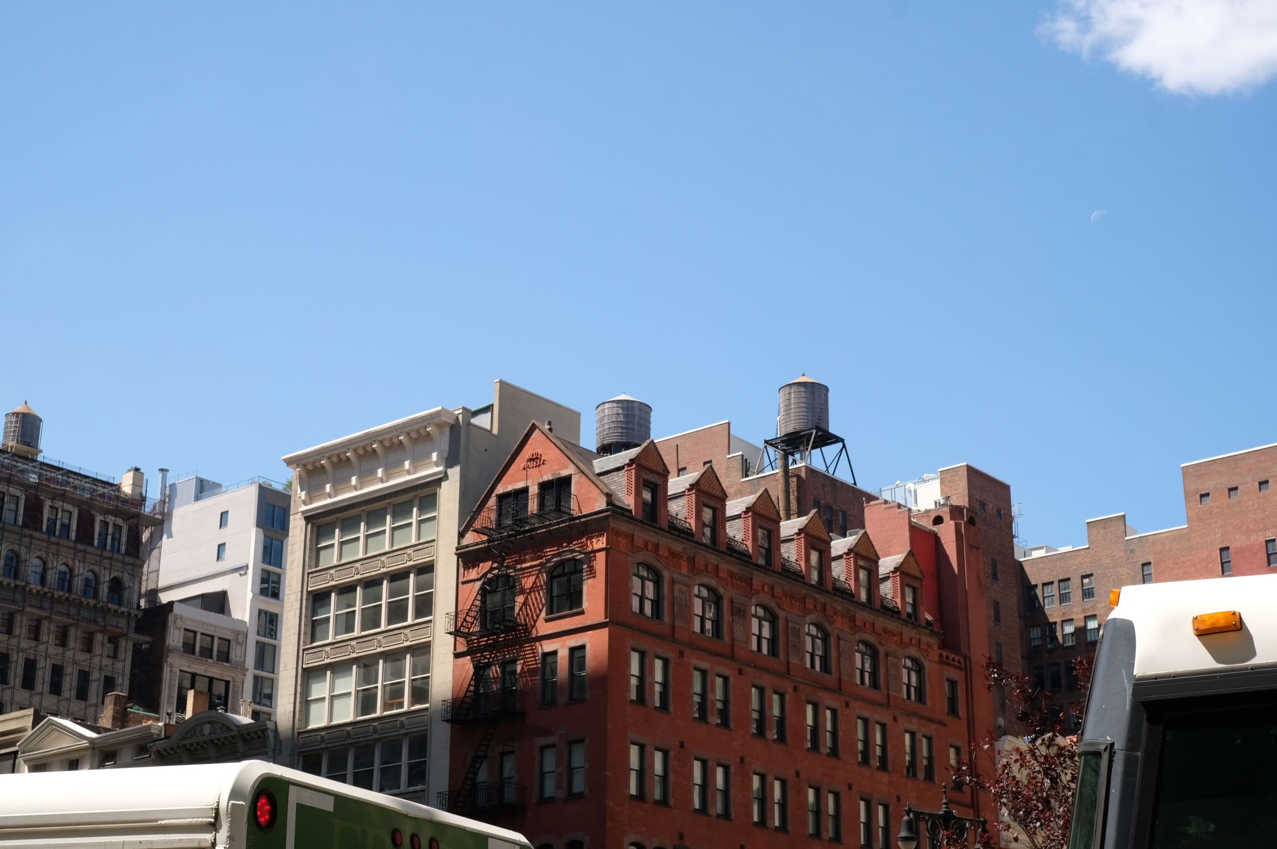 Affordable Charter Buses NYC – What It Actually Feels Like in 2026 4 Historic and modern buildings with iconic water towers under a bright blue sky in New York City.