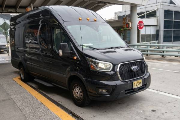 Ford Transit van at airport terminal curb - Zolo group transfers